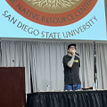 man stands at podium speaking