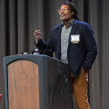 man stands at podium speaking