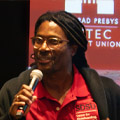 man from Center for Skateboarding, Action Sports, and Social Change smiles as he speaks to crowd