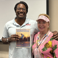 smiling man and woman, man holds comic book on skateboarding
