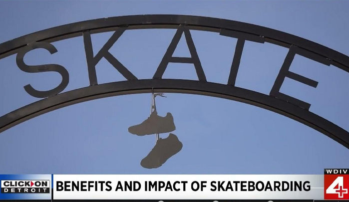 Sign that says Skate with tennis shoes hanging from it